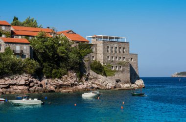 Karadağ, Avrupa, Adriyatik Denizi ve dağları yakınlarındaki Sveti-Stefan adası yakınlarındaki teknelerin güzel manzarası