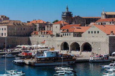 Hırvatistan 'ın Dubrovnik kenti, limana tarihi Dubrovnik kentinin arka planına sahip yelkenli ve zevk tekneleriyle bakıyor 