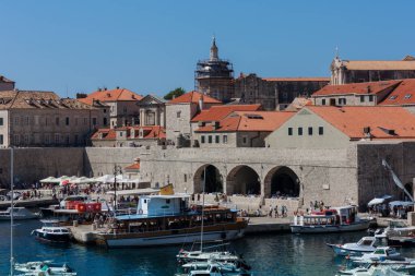 Hırvatistan 'ın Dubrovnik kenti, limana tarihi Dubrovnik kentinin arka planına sahip yelkenli ve zevk tekneleriyle bakıyor 