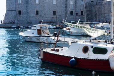 Hırvatistan 'ın Dubrovnik kenti, limana tarihi Dubrovnik kentinin arka planına sahip yelkenli ve zevk tekneleriyle bakıyor 