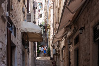 Hırvatistan 'ın Dubrovnik kenti, limana tarihi Dubrovnik kentinin arka planına sahip yelkenli ve zevk tekneleriyle bakıyor 