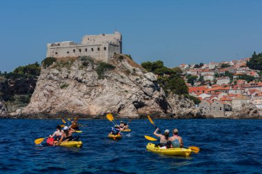 Hırvatistan 'ın Dubrovnik kenti, limana tarihi Dubrovnik kentinin arka planına sahip yelkenli ve zevk tekneleriyle bakıyor 