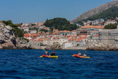 Hırvatistan 'ın Dubrovnik kenti, limana tarihi Dubrovnik kentinin arka planına sahip yelkenli ve zevk tekneleriyle bakıyor 