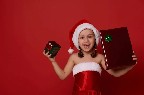 Entzückend Fröhliches Kleines Mädchen Weihnachtsmannkostüm Hält Weihnachtsgeschenkschachtel Grünem Und Rotem — Stockfoto