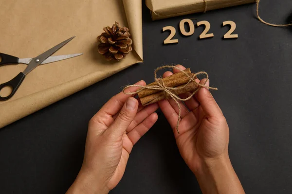 将肉桂绑在一起 包裹礼物和为圣诞节传统活动制作手工礼物的人的手的特写 手工艺艺术 — 图库照片