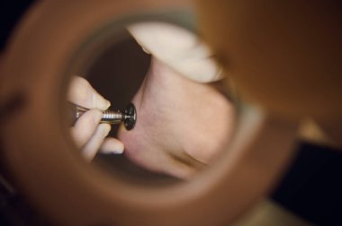 Uzman pedikür uzmanı, ayak hastalıkları uzmanı, kayropodist tarafından tedavi edilen hafif ayaklara tıbbi bir lamba ile yakından bakın. Vücut ve tırnak bakımı kavramı