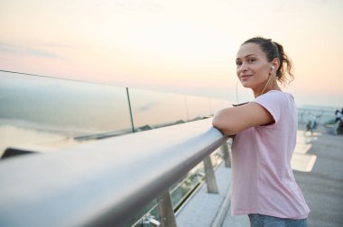 Genç İspanyol atlet şehir köprüsünde duruyor, güneş doğarken sabah kardiyo antrenmanından sonra dinleniyor. Spor, sağlıklı aktif yaşam tarzı, kilo kaybı, spor, motivasyon ve sağlık konsepti