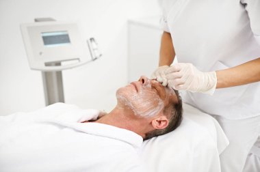 Olgun 50 yaşındaki bir adam modern sağlık merkezlerinde gençleştirici gençleştirici gençleştirici güzellik tedavisi görüyor.