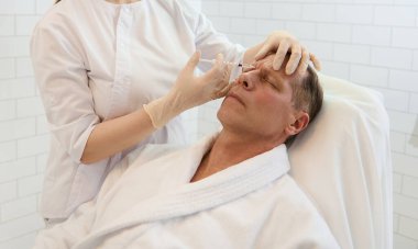 Kozmetikçi, yaşlanma ve ifade çizgilerinin erken belirtilerini önlemek için yaşlı bir adamı glabellar bölgeye enjekte ediyor. Modern kaplıca kliniğinde güzellik iğnesi ve yaşlanma karşıtı tedaviler alan olgun bir adam.