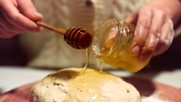一个女人的手拿着一个开膛手 把它放进一个盛有蜂蜜的罐子里 然后把蜂蜜倒在面团上 做成一个面团做甜姜饼 糕点概念 — 图库视频影像