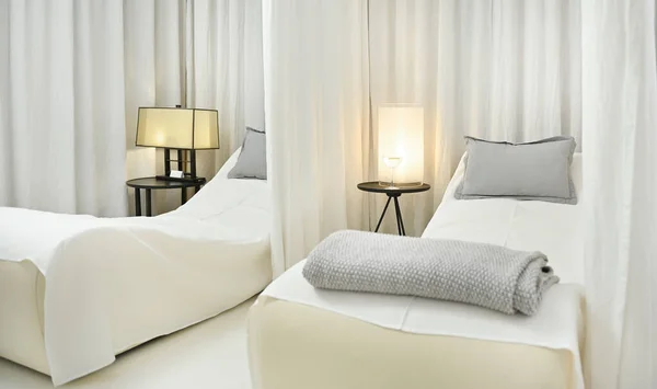 一间有两张床的私人按摩室的漂亮奢华的白色内饰 可供两人休息 并可在一间现代化的健康温泉中享用 — 图库照片
