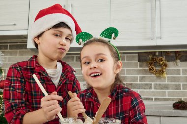 Neşeli şirin çocuklar şımarır, ev mutfağında birlikte eğlenir, Noel pastası ve kurabiyeler için hamur hazırlarlar. Çocukların kendileri mutfaktalar. Mutluluk... birlikte sevinmektir.