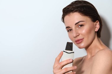 Ultrason kozmetoloji temizleyicisi. Yüz boşaltımı prosedürü. Cilt bakımı. Profesyonel kabuk soyma donanımı. Yakın plan çekici kadın yüzüne elektrikli spa ekipmanı sürüyor. Boşluğu kopyala