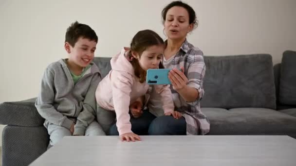 Happy Mother Sits Couch Next Her Cute Children Living Room — Vídeo de Stock