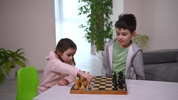 Cute Little Girl Plays Chess Chaotically Her Brother Who Teaches — Vídeo de Stock