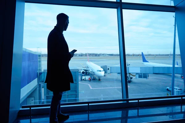 Silhouette Businessman Airport Lounge Mobile Phone Standing Panoramic Windows Overlooking — Stock fotografie