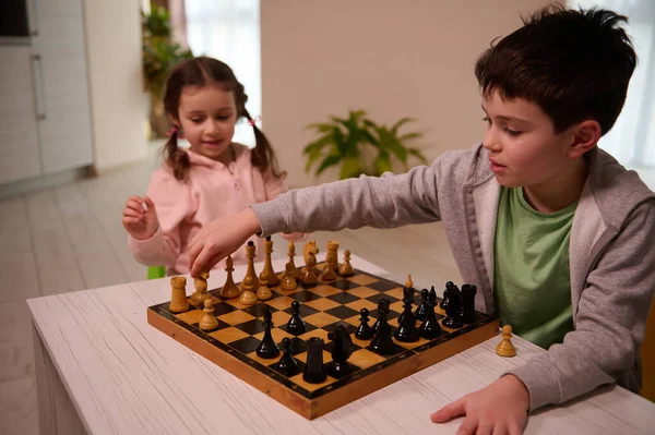 Snygg Pojke Med Seriös Blick Sitter Vid Bordet Och Spelar — Stockfoto