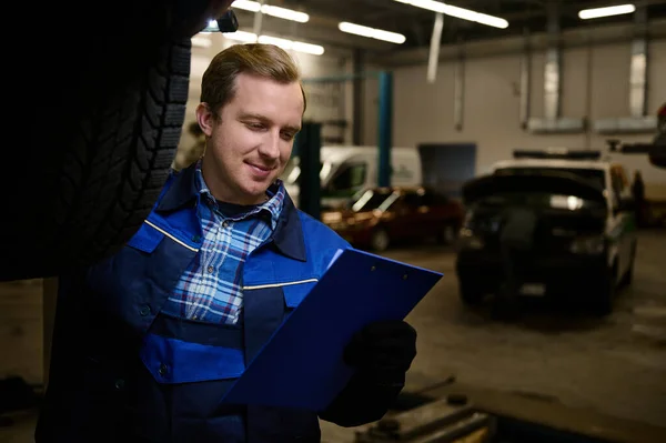 남자의 초상화 자동차 정비공 기술자 정비소에서 내리는 점검하는 클립보드에 리스트를 — 스톡 사진
