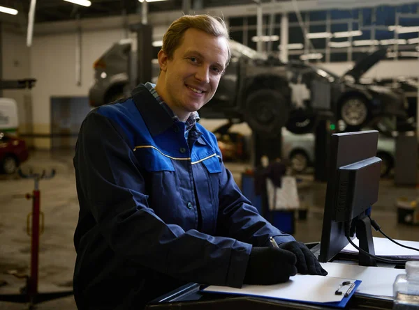 Skoncentrowany Mechanik Samochodowy Inżynier Uśmiecha Się Patrząc Listę Kontrolną Zapisu — Zdjęcie stockowe