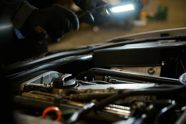 Zbliżenie Rąk Mechanika Samochodowego Sprawdzającego Silnik Samochodu Świecącą Latarką — Zdjęcie stockowe