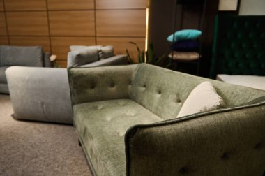 Modern stil yumuşak yumuşak döşeme, bej yastıklı yeşil zeytin kadife mobilya mağazasının vitrininde satılık.
