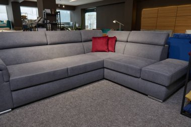 Mobilya mağazasının galerisinde satılık döşenmiş mobilyalar. Sergi salonundaki kaliteli kumaşlardan parlak renkli yastıklara sahip modern şık kanepeler, kanepeler ve kanepeler..