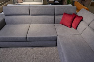 Mobilya mağazasının galerisinde satılık döşenmiş mobilyalar. Sergi salonundaki kaliteli kumaşlardan parlak renkli yastıklara sahip modern şık kanepeler, kanepeler ve kanepeler..