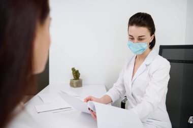 Kadın estetikçi ya da pratisyen doktor klinikte bir kadın hastaya danışıyor. Sağlık ve ilaç. Kozmetik, cilt bakımı, güzellik tedavisi