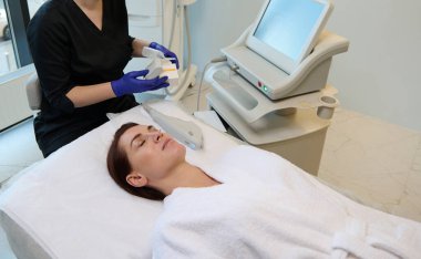 Orta yaşlı, güzel bir beyaz kadın güzellik merkezinde yüzüne güzellik tedavisi uygulanıyor. Vücut bakımı, yaşlanma karşıtı terapi, sağlık hizmetleri ve tıbbi konsept. Kozmetoloji dermatolojisi