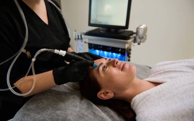 Güzel bir Avrupalı kadın, modern bir sağlık merkezinde yüzüne güzellik tedavisi yaptırıyor. Yaşlanma karşıtı tedavi, gençleştirme, güzellik terapisi. Kozmetoloji ve dermatoloji kavramı