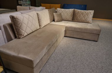 Mobilya mağazasının galerisinde satılık döşenmiş mobilyalar. Sergi salonundaki kaliteli kumaşlardan parlak renkli yastıklara sahip modern şık kanepeler, kanepeler ve kanepeler..