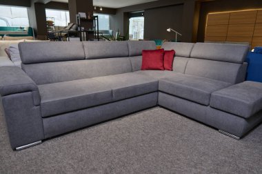 Mobilya mağazasının galerisinde satılık döşenmiş mobilyalar. Sergi salonundaki kaliteli kumaşlardan parlak renkli yastıklara sahip modern şık kanepeler, kanepeler ve kanepeler..