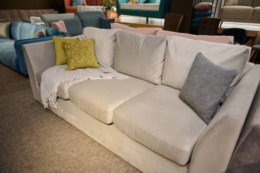 Mobilya mağazasında satılık renkli yeşil zeytin yastıklı rahat döşemeli kanepe. Döşeme mobilyalarının sergilenmesi.