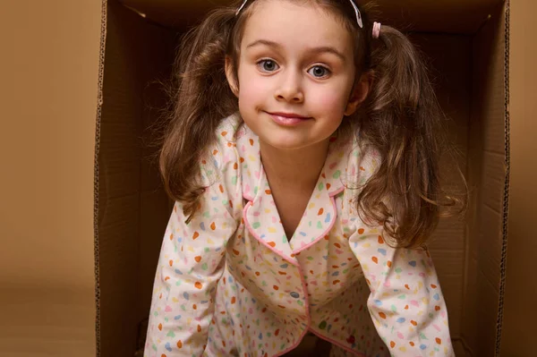 Close Baby Girl Two Ponytails Pajamas Peeking Out Cardboard Box — ストック写真