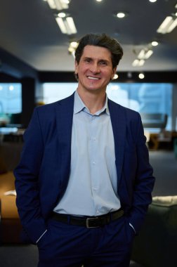 Yakışıklı, kendine güvenen beyaz bir adamın iş portresi. Girişimci, iş adamı. Güzel dişli bir gülümsemeyle kameraya bakıyor.