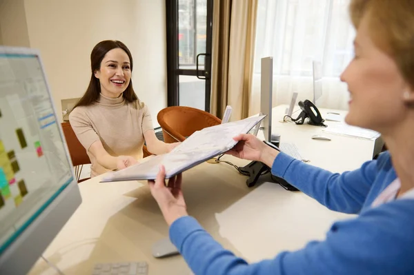 Human resources, Recruitment, job application, contract and business employment concept. Two female recruiters looking through a folder with resume documents of candidates for a vacant position