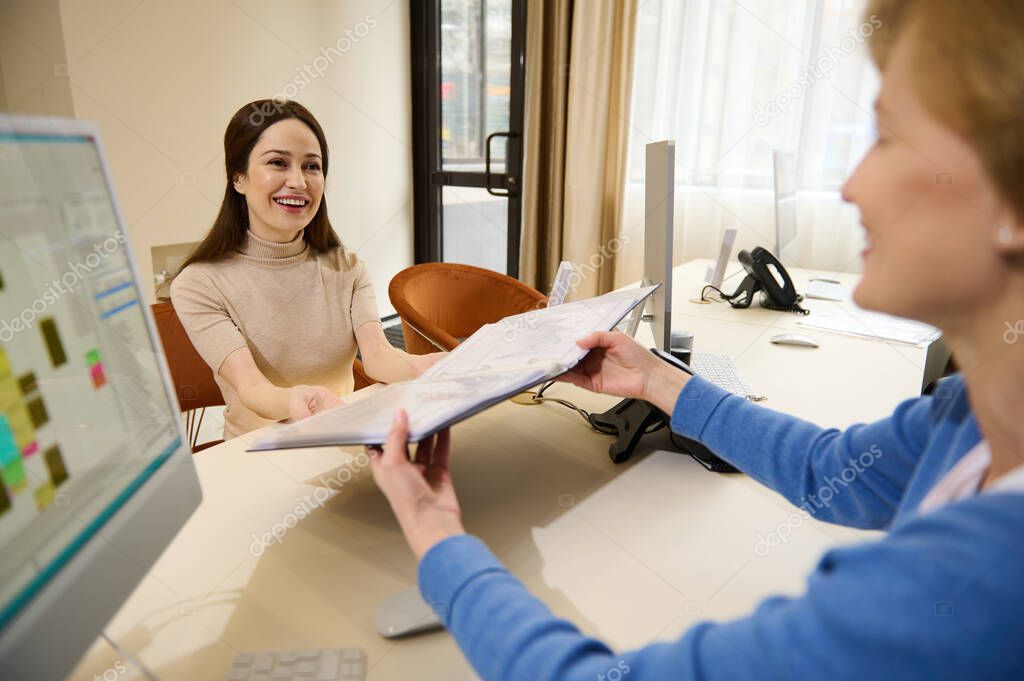 Human resources, Recruitment, job application, contract and business employment concept. Two female recruiters looking through a folder with resume documents of candidates for a vacant position