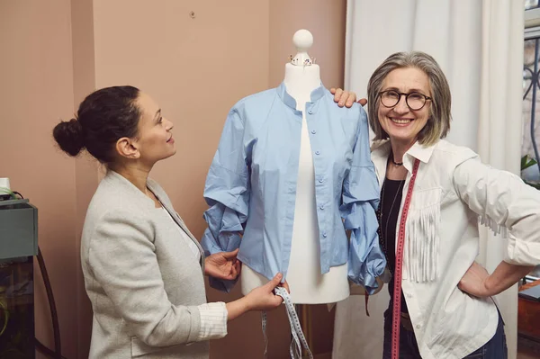 Fashion designers working with a mannequin in fashion design atelier. Tailoring, creation of new garment collection, fashion designer business start-up concept