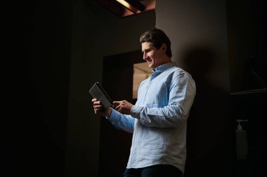 Yakışıklı girişimci, satış müdürü, iç mimar, iş adamı dijital alet kontrolü siparişleri alıyor ve mobilya tasarım stüdyosunun şık bir ofisinde yeni tasarım ve iş projeleri planlıyor.