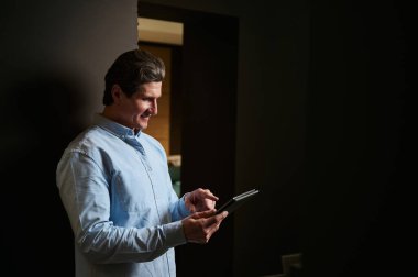 Bir işadamının, girişimcinin, satış asistanının ve iç tasarımcının dijital cihaz kullanarak şık bir mobilya tasarım deposunda siparişleri kontrol eden yarı uzunlukta özgüvenli iş portresi.