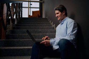 Yakışıklı, kendine güvenen, olgun Avrupalı bir iş adamı dizüstü bilgisayarla uzaktan çalışıyor, yeni bir proje planlıyor ve yeni sanat bürosunda yeni iş stratejisi geliştiriyor. İş, Çevrimiçi meslek.