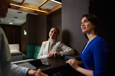 Orta yaşlı Avrupalı evli çift yeni mobilya alışverişi yapıyor, ev tasarımı stüdyosundaki bir perakende danışmanıyla konuşuyor.