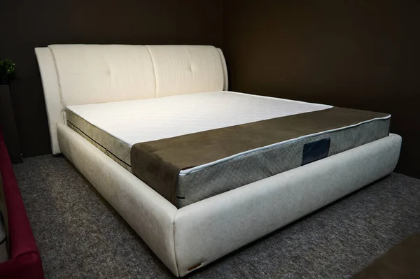 A modern stylish velour double beds with orthopedic hard mattresses, displayed in the showroom of a furniture store