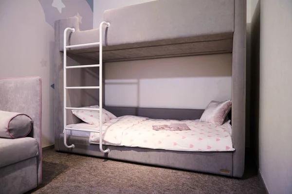 Comfortable bunk bed family bedroom concept idea. Model of designed children bedchamber displayed for sale in a furniture showroom. Stylish kids bedroom