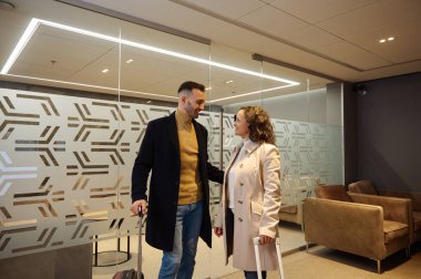 Uluslararası havaalanının kalkış terminalinin VIP salonunda birlikte konuşan iş ortaklarından oluşan bir ekip uçağa binmeyi bekliyor.