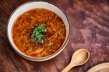 Ukrayna Borş 'u ahşap bir masada dereotlu ve maydanozlu bir kasede servis edilir. Geleneksel pancar çorbası, Ukrayna ve Rus ulusal mutfağı. Reklam metni için boşluk kopyala. Üst görünüm