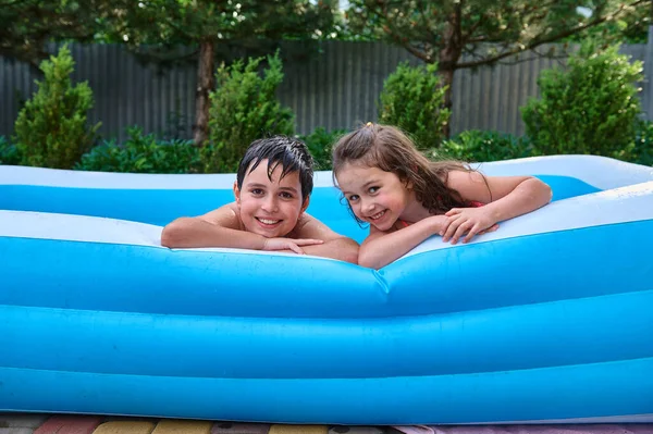 Lifestyle Portrait Two Cheerful Caucasian Children Brothers Sisters Swimming Inflatable — Zdjęcie stockowe