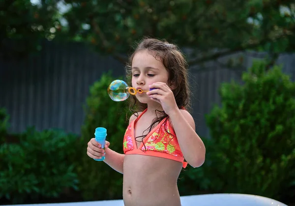 Caucasian Funny Little Girl Dressed Bright Swimsuit Blowing Soap Balls — Zdjęcie stockowe