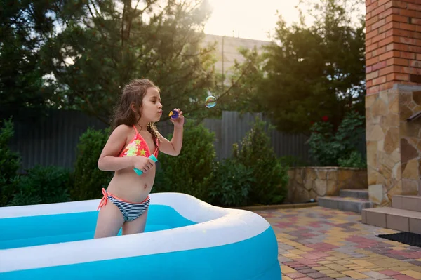 Beautiful Caucasian Girl Bathing Suit Catches Soap Bubbles She Blows — Zdjęcie stockowe
