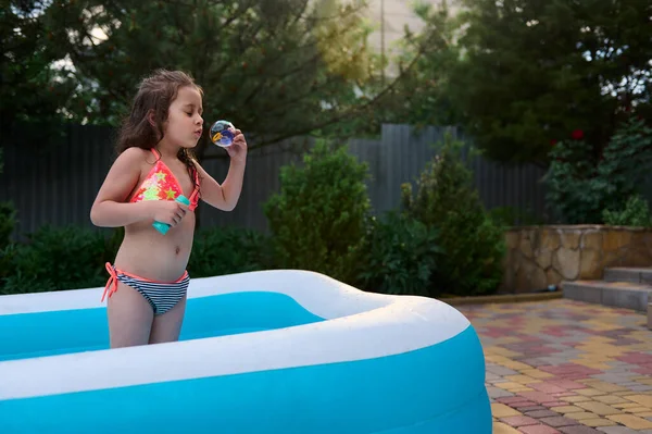 Adorable Years Old Baby Girl Bathing Suit Blows Soap Bubbles — Zdjęcie stockowe